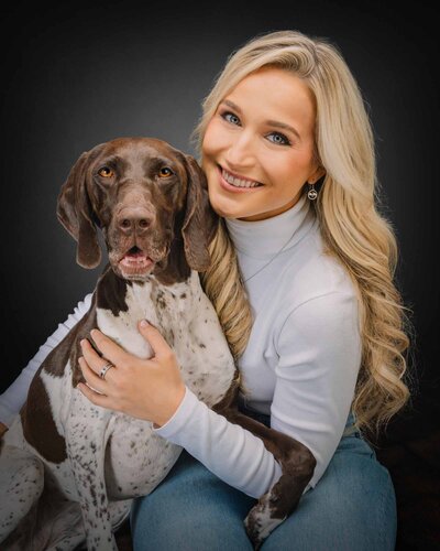 blonde woman hugging german shorthair pointer dog smiling