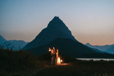 A blue hour portrait with lanterns in front of a mountain.