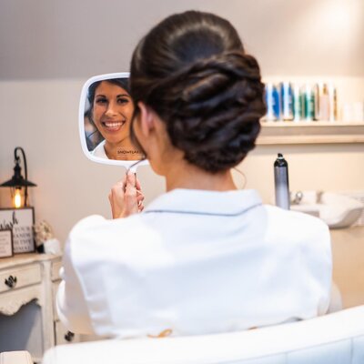 bride admiring herself after her hair is done