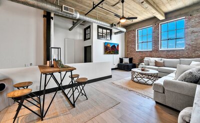 Dining area with seating for four in this three-bedroom, two-bathroom industrial modern loft condo in the historic Behrens building in downtown Waco, TX.