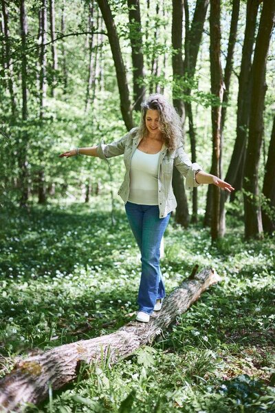 Sarka, a life coach from Brno, balancing on a fallen tree in the forest