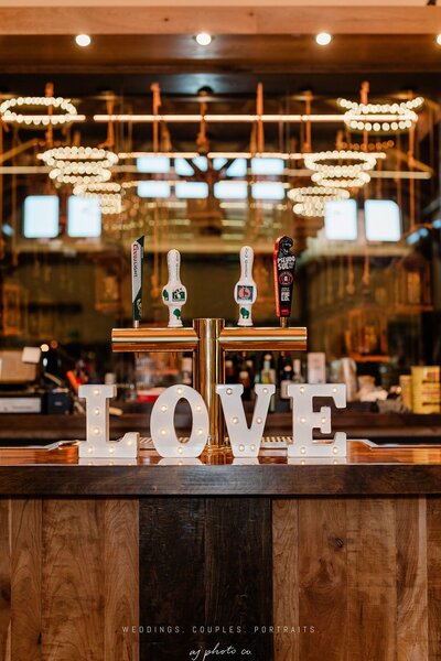 love signage at the bar counter at barnwood events, a wedding venue in madison, winconsin.