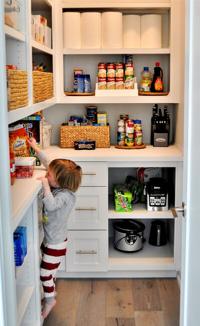 Image of little boy looking for a snacks in a well designed pantry - appliance garage