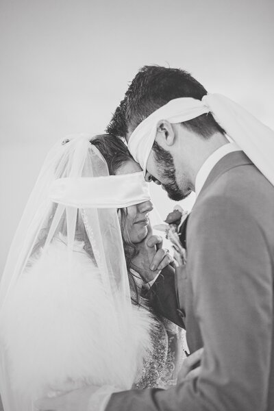 bride and groom with eyes blindfolded during their first touch