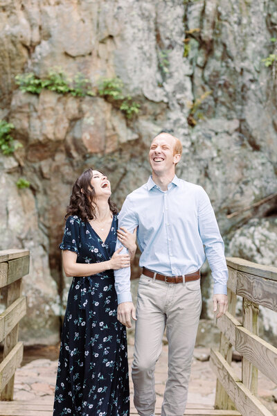 engaged couple walking together on a bridge