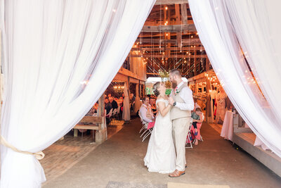 bride and groom dancing in a barn