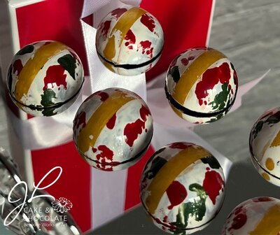hand-painted luxury chocolate bonbons in gold, green, and red 