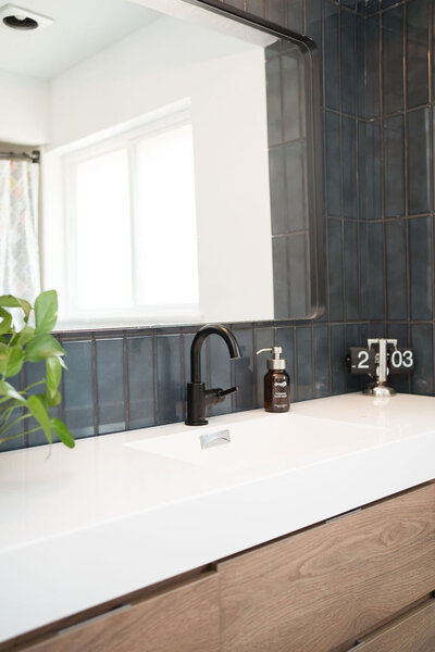 Mid-Century Modern Bathroom with wood vanity and dark glazed tile backsplash