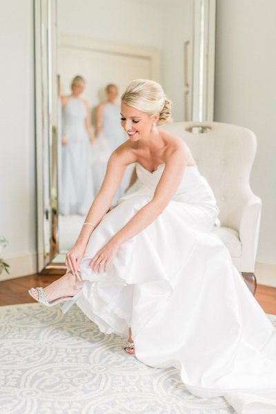 bride gets puts on her wedding shoes in the bridal suite on her wedding day