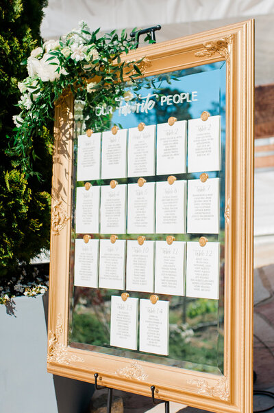 Rental mirror for wedding seating chart with paper seating chart cards attached with gold wax seals
