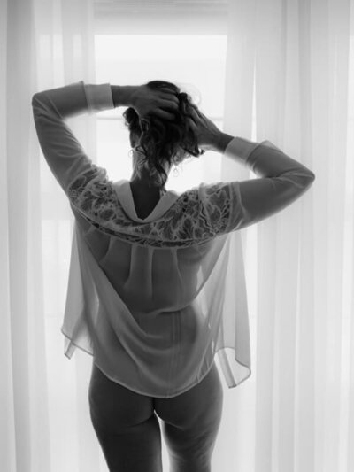 Vrouw in wit hemdje tegen het licht, silhouet vol zachtheid en vrouwelijke kracht

