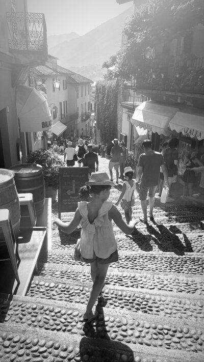 Black and white photograph of daughter walking down cobble lock steps in Bellagio.
