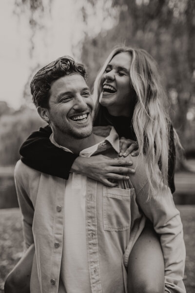 man and woman laughing at their engagement session at the boston common gardens