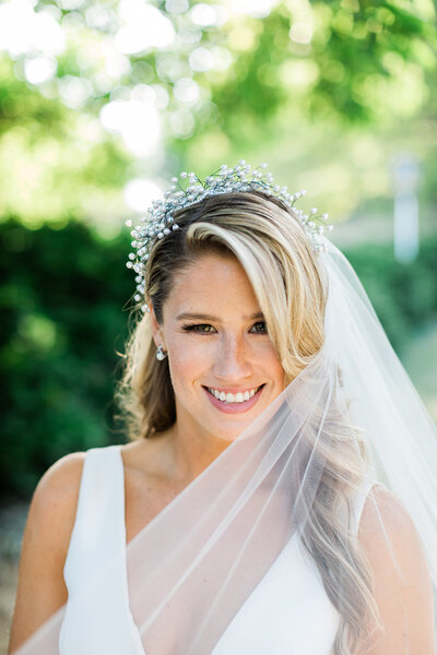 Bride Wearing Flower Crown and Veil smiles at camera