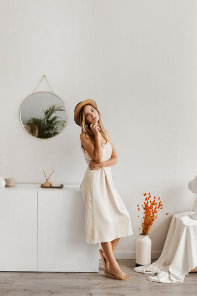 beautiful-young-woman-light-dress-hat-posing-interior-model-girl-summer-outfit-with-big-bag-cozy-interior-summer-fashion