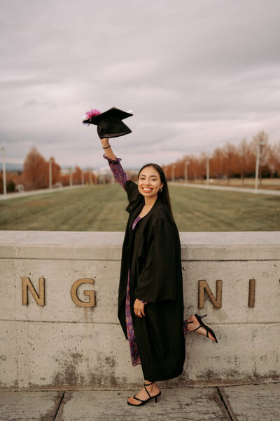 Woman holding her graduation cap in the air at BYU-Idaho