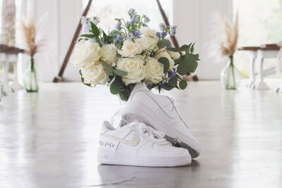 Bride's Nike Air Force One's with wedding rings and bouquet taken by  Arlene Stepanian, Dallas Wedding Photographer