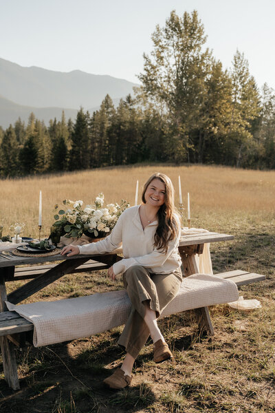 Sydney Breann poses after setting up a tablescape with a mountain view near Glacier National Park.