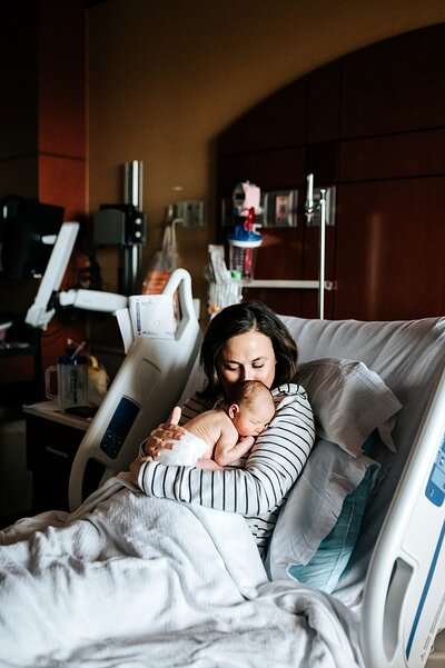 mother holding brand new baby in a hospital room