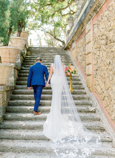 bride and groom walking up estate stairs