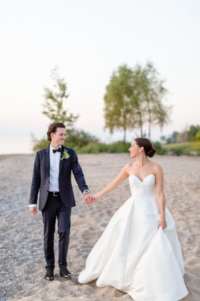 Sarah  Jonathan Zurich Ontario Beach Wedding walking along beach at sunset