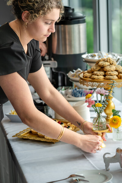 Catering staff arranging desserts and flowers on table before reception – photographed by wedding photographer Niko Coric – Lumen Clarity Media