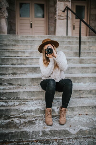 Sacramento Wedding Photographer captures woman sitting on stairs holding camera