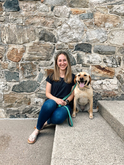 Cornerstone Dog Trainer, Emily, sitting next to her dog Timber