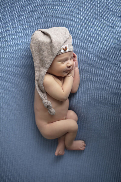 Dallas newborn boy posed on blue fabric.