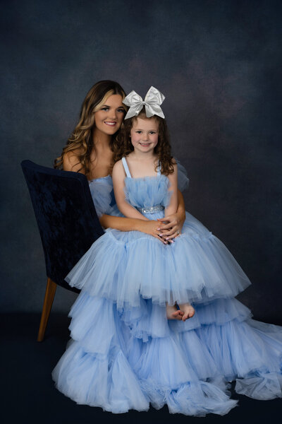 mom-and-daughter-posing-in-studio-blue-couture-dresses