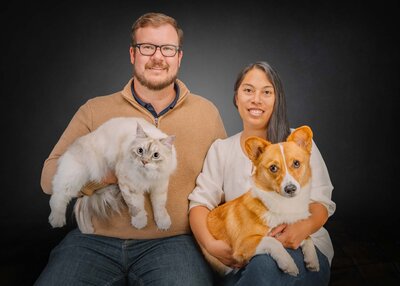 couple posing with corgi and white cat