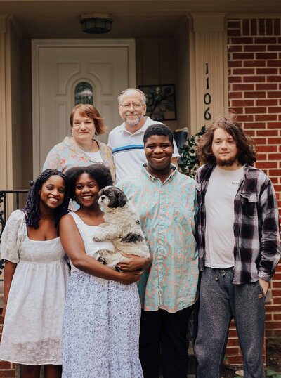 Maddie Rae Photography family portrait, they are standing on the steps of their front porch