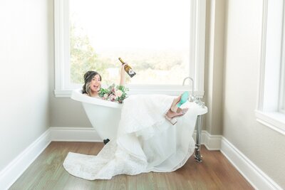 A bride celebrating in the clawfoot tub in the bridal suite.