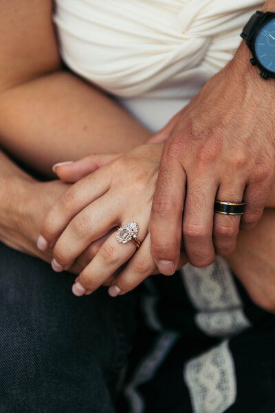 A close-up of hands, tenderly intertwined, conveying the warmth and closeness of the couple in this heartfelt moment