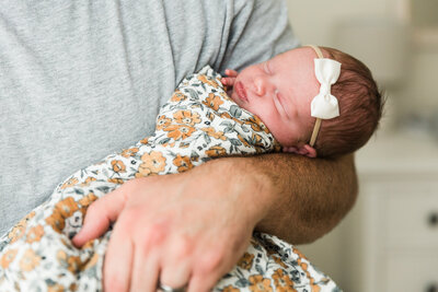 closeup of dad holding sleeping baby girl