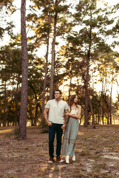 young couple in stylish clothing stands holding hands at sunset in niceville florida