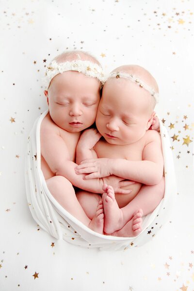 Newborn baby posing with their hands under their chin