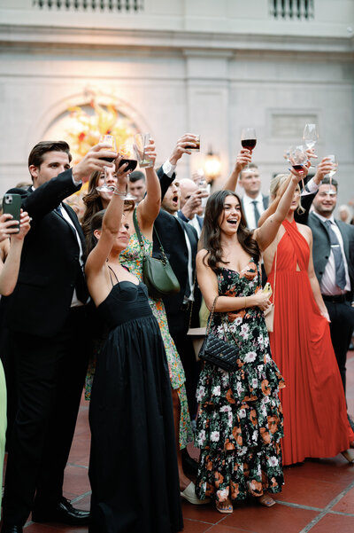 guests having a great time at a wedding raising a glass