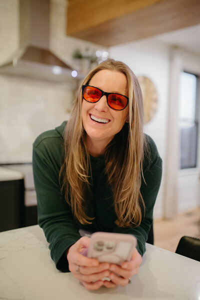 Woman wearing blue light blocking glasses and smiling