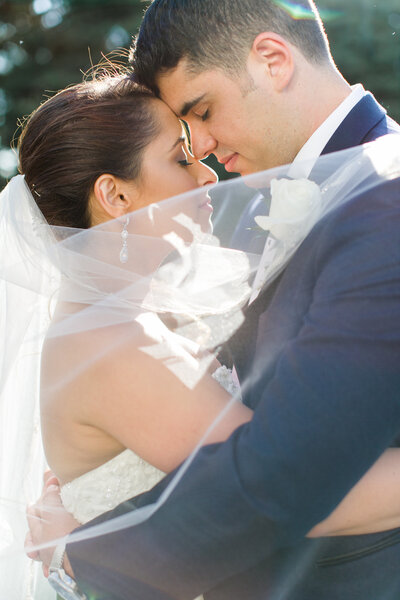 Bride & Groom embracing with veil accent