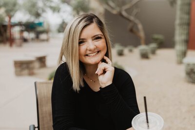 Arizona wedding photographer smiles while working at a coffee shop