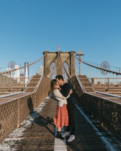 man and woman kissing on brooklyn bridge nyc