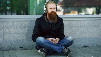 Man using headphones for trauma-informed nervous system regulation in an outdoor setting