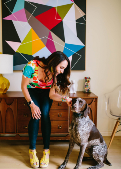 Woman in a bright colorful home with a dog