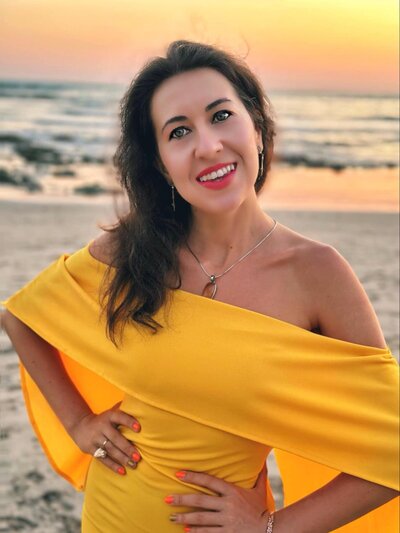 Life coach Ana-Maria Georgieva in a yellow dress on a beach