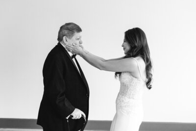 bride touching dad's face during first look at luxury wedding in Chicago
