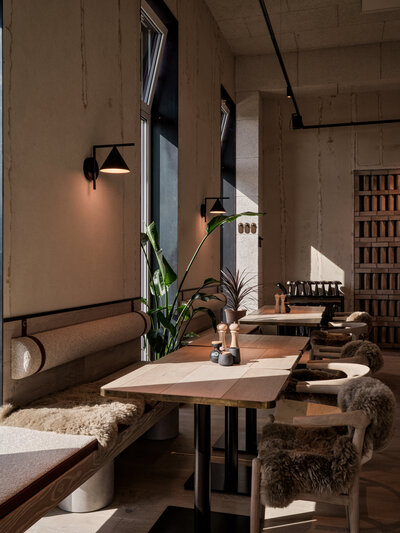 Sonniger Sitzplatz am Fenster des Restaurants BRACA im the breeze Hotel.