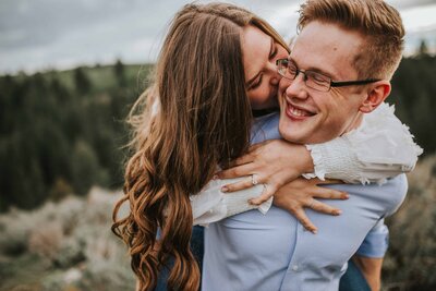 girl on back of boy kissing on a mountain in tennessee engagement photos