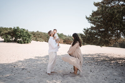 Spelenderwijs moment tussen ouders en kinderen tijdens gezinsfotoshoot door Leukfotografie in Soesterduinen