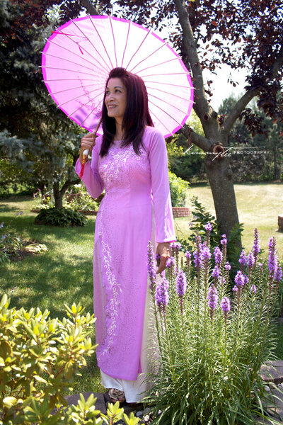 Woman holding umbrella in a pink Vietnamese dress